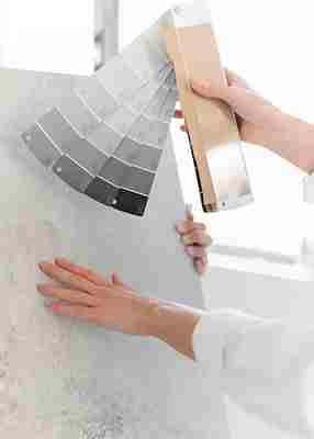 Outdoor cafe renovated in Romford with wicker tables and chairs, sunlight filtering through large glass windows, surrounded by greenery and city skyline.