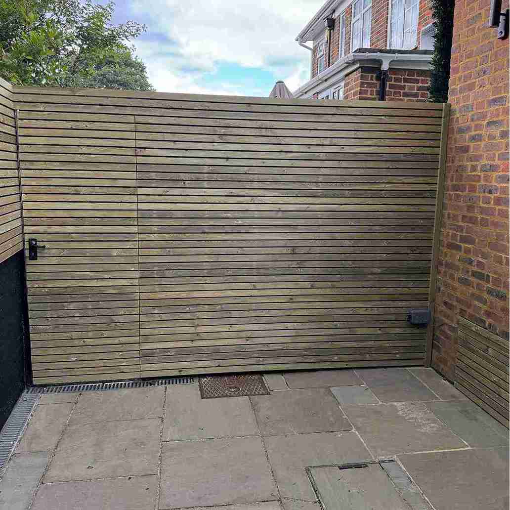 Sleek wooden gate with horizontal slats installed in a paved driveway, enhancing the curb appeal of a property in Essex.