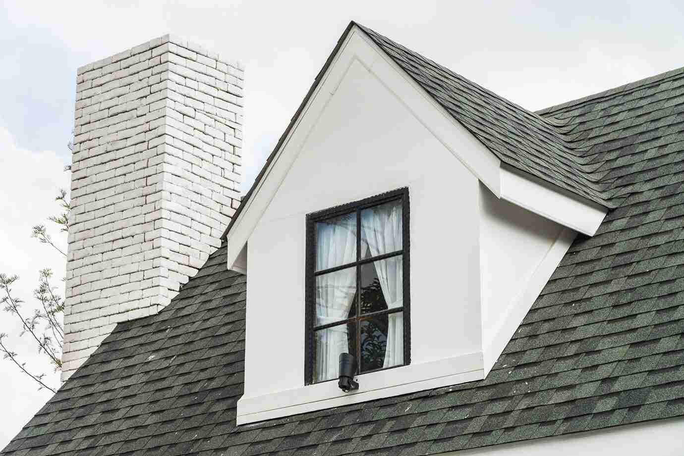Close-up of a pitched roof showcasing a modern dormer window and white brick chimney, part of a stylish loft conversion in Romford, East London.